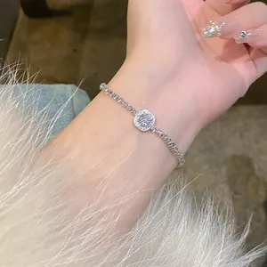 Close-up detail of a silver bracelet with a sparkling square zircon center on a wrist.