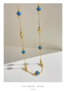 Close-up of a vintage necklace with blue round beads and textured gold spacers.
