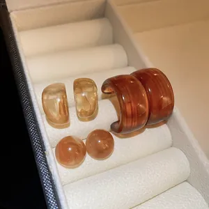 Detailed close-up view of three pairs of retro coffee-colored resin earrings in a gift box