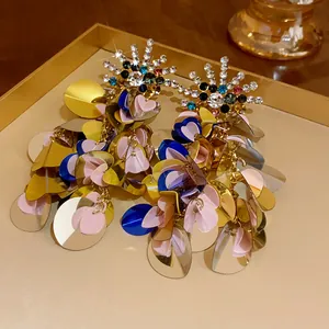 Detail view of exaggerated bohemian sequin earrings with sparkling multi-colored rhinestones.