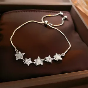 Detailed view of silver star bracelet with shimmering cat's eye stones and zircon
