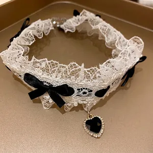 Elegante choker in pizzo bianco con fiocchi neri e ciondolo a cuore scintillante
