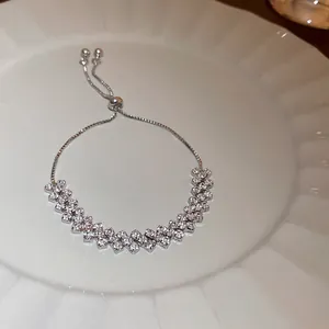 Detail view of a sparkling cubic zirconia adjustable bracelet on a white plate