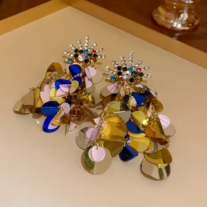Close-up of colorful sequin drop earrings with sparkling rhinestone starburst tops