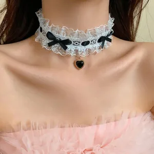 Elegante choker in pizzo bianco con fiocchi di raso neri e ciondolo a cuore su modella