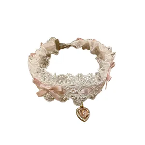 Collana girocollo in pizzo bianco con fiocco rosa e ciondolo a cuore in strass scintillante