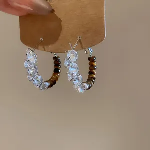 Close-up of vintage Tiger Eye beaded hoop earrings with sparkling stones and gold plating