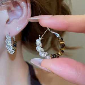 Macro view of vintage style tiger eye beaded hoop earrings with sparkling crystal accents