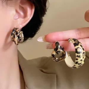 Macro view of vintage leopard print geometric double hoop earrings with a smooth resin finish
