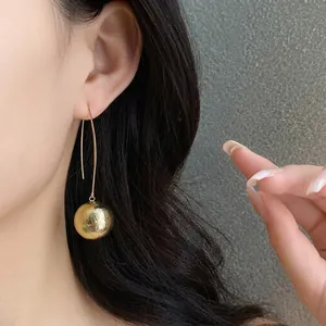 Statement gold textured ball drop earrings with elegant long curved hooks for women
