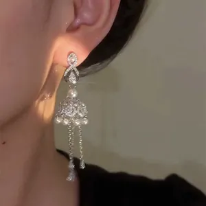 Elegant long silver needle earrings with pavé zircons and pearls featuring delicate tassels.