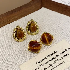 Close-up of vintage Maillard brown resin stud earrings in round and teardrop shapes