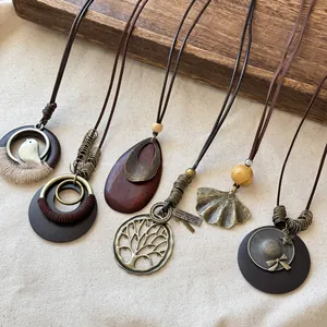 Close-up of Bohemian ethnic long necklaces with vintage bronze pendants on wood