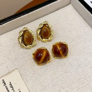 Detail view of vintage Maillard style resin stud earrings with elegant gold-toned frames.