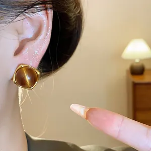 Close-up detail of a vintage resin square stud earring in brown Maillard style worn on ear