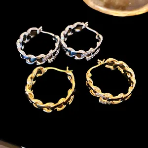 Vue détaillée de boucles d'oreilles créoles à maillons en or et argent avec zircons