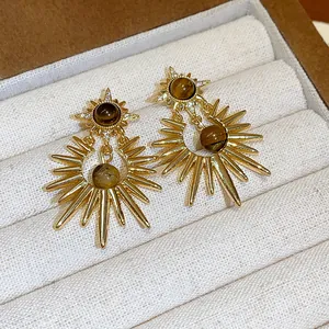Detailed view of vintage sunburst earrings with tiger eye stone and zircon accents