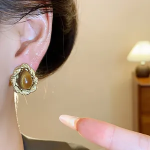 Close-up detail of a vintage Maillard style resin stud earring with gold rope texture