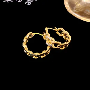 Détail de boucles d'oreilles créoles à maillons dorés avec oxydes de zirconium