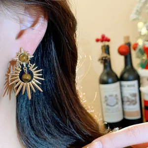 Detail view of vintage sunburst earrings featuring tiger eye stone and zircon accents.