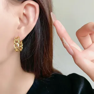 Vue détaillée de boucles d'oreilles créoles à maillons dorés avec zircons sur modèle