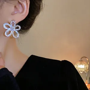 Eleganti orecchini a lobo a fiore con strass e aghi in argento, indossati sul lobo
