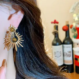 Close-up detail of vintage sunburst earrings with tiger's eye stones and silver needles