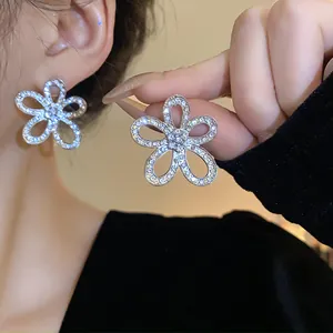 Dettaglio ravvicinato di orecchini a fiore a cinque petali con strass brillanti