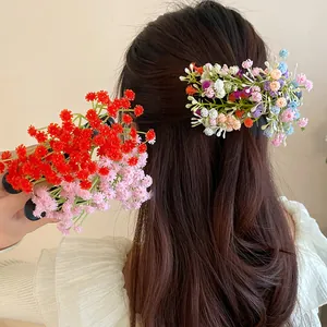 Detailed view of colorful floral cluster hair clips worn by a model in a sweet forest style.