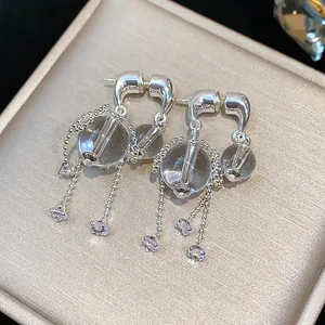 Detailaufnahme eleganter silberner Quastenohrringe mit Glasperlen und Zirkonia