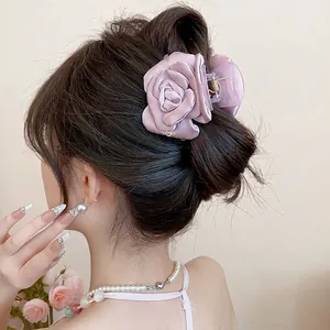Elegant mauve silk satin rose flower hair claw clip on model's hair.