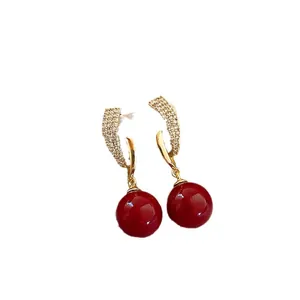 Elegant gold-plated drop earrings with deep red pearls and sparkling zircon accents