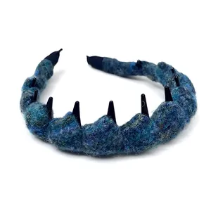 Trendiger blau gestrickter Haarreif mit schwarzen Stacheln für moderne Herbstfrisuren