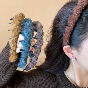 Detailansicht strukturierter Strickstirnbänder in warmen Herbstfarben auf Model