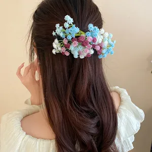 Detailed macro shot of a fresh floral hair clip worn on long brown hair