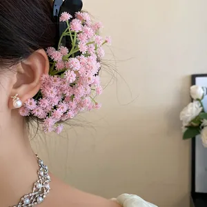 Detailed close-up of a sweet pink flower cluster hair clip worn on a model's hair.