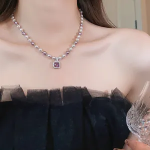 Close-up of elegant French style pearl necklace featuring a purple square zircon pendant