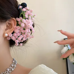 Detailed close-up of a pink floral hair clip styled on a woman's updo for a sweet look