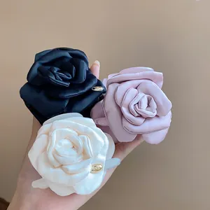 Detailed macro view of satin fabric rose hair clips with elegant gold heart tags