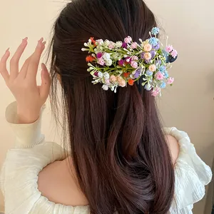 Close-up of a colorful forest-style floral cluster hair clip on beautiful wavy hair