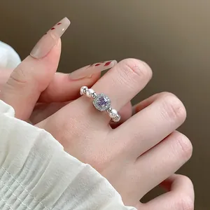 Close-up of a French style ring featuring a purple square zircon and white pearls.