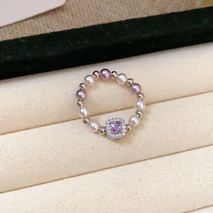 French style pearl ring with a square purple zircon centerpiece in a jewelry box.