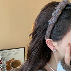 Nahaufnahme eines braun gestrickten geflochtenen Stirnbandes, schickes Winter-Haar-Accessoire.