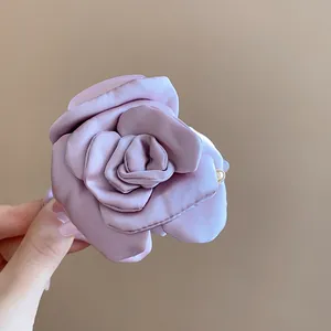 Detailed view of a purple satin fabric flower hair claw clip with elegant petal layers