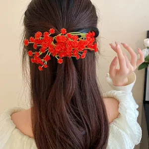 Detailed view of a red floral hair clip styled on brown hair for a sweet look