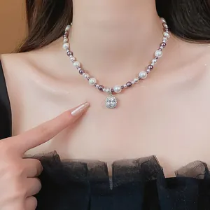 Close-up of a French style pearl necklace featuring a square zircon pendant on a model