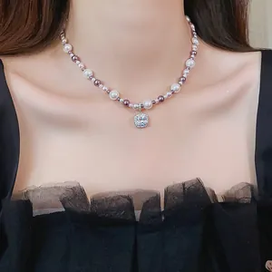 Detailed close-up of an elegant pearl necklace with a square zircon pendant on a model