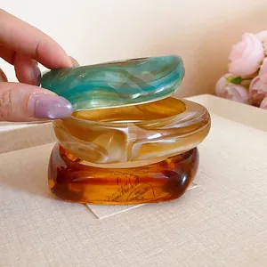 Elegant marble striped square resin bangles in blue, beige, and amber colors