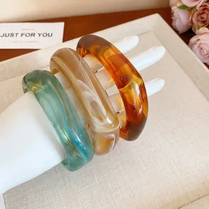 Stylish square marbled resin bangles in amber, cream, and teal colors.