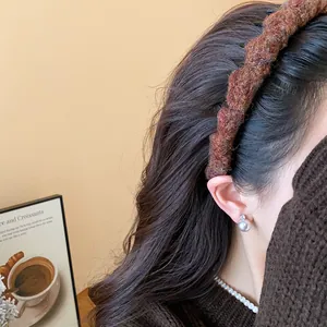 Detailansicht einer Frau mit einem braunen geflochtenen Wollstirnband für einen Winterlook